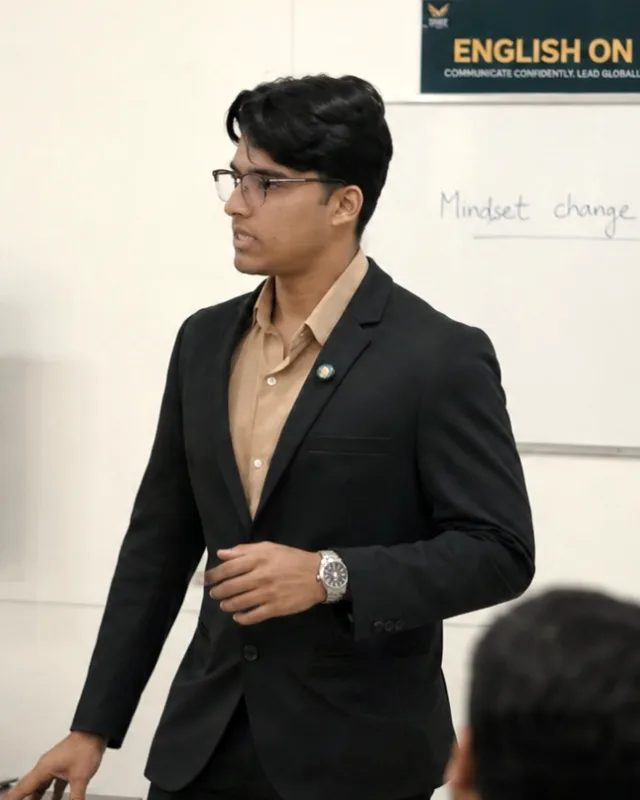 Jonah Joy in glasses teaching a small room of professionals at a whiteboard